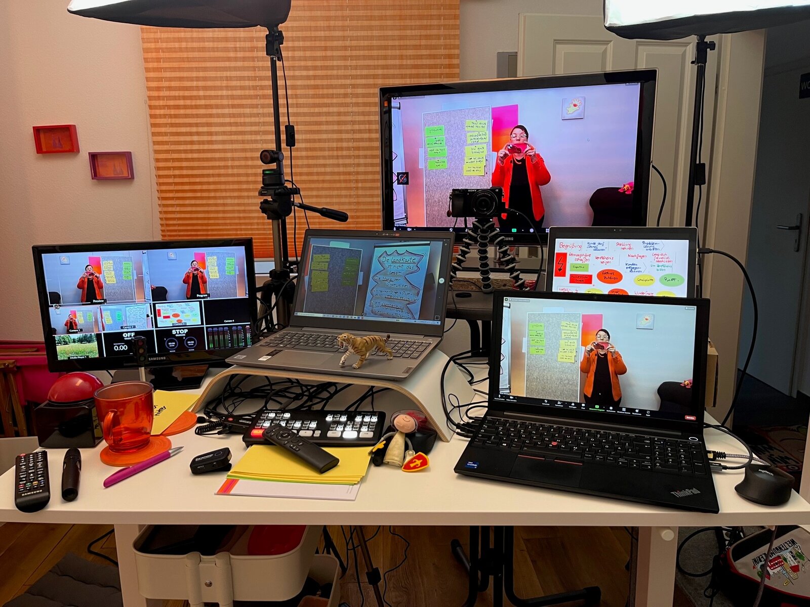 Der Online-Trainings-Schreibtisch mit mehreren Bildschirmen, Laptops, Kamera und Streaming-Technik